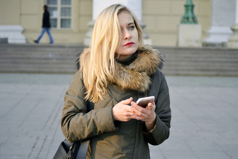 blonde girl with a phone on her hands